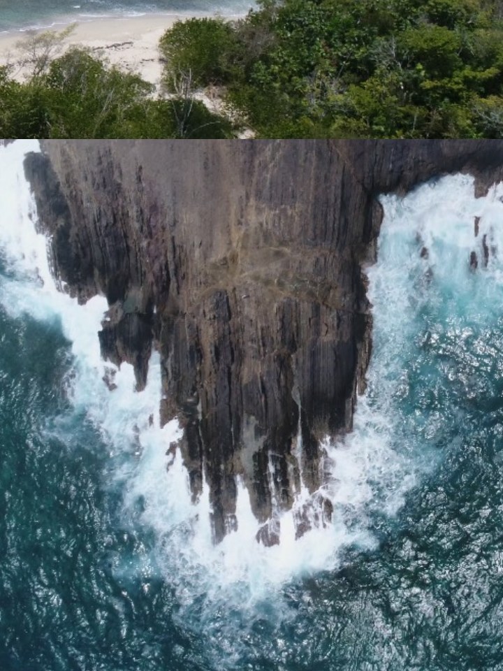Waves breaking against dramatic Caribbean cliffs.